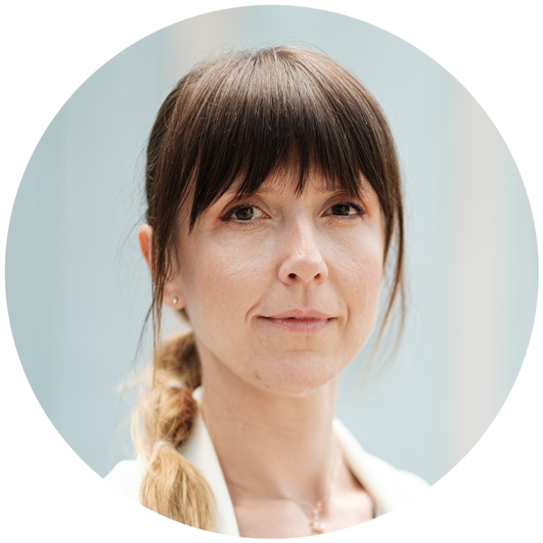 Patrycja Hochmańska-Haniewska, ekspertka Łukasiewicz - PIT, kobieta z warkoczem i grzywką na szaroniebieskim tle