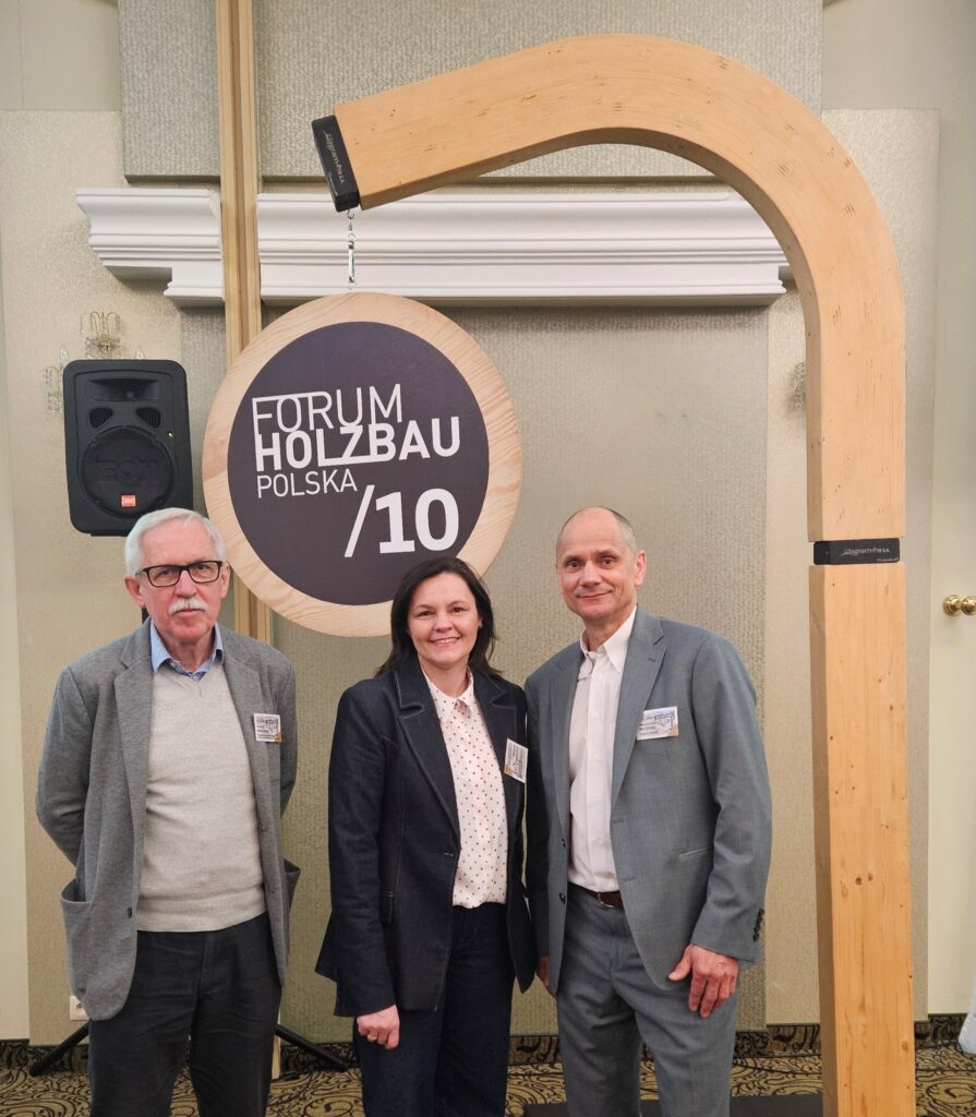 Dwóch mężczyzn i kobieta pod znakiem "Forum Holzbau"