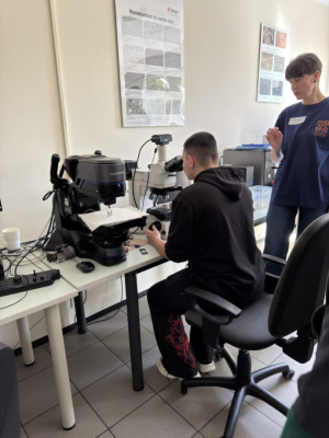 Uczeń patrzy przez mikroskop w laboratorium