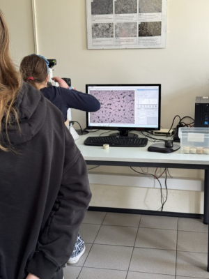 Uczennica patrzy przez mikroskop w laboratorium