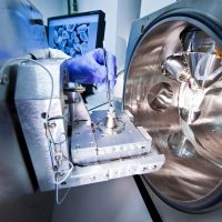 Badanie próbek w mikroskopie elektronowym – proces przygotowania i analizy materiału Komora mikroskopu elektronowego z uchwytem na próbkę i manipulatorem