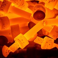 Rozżarzone metalowe elementy, mające barwę pomarańczowo-żółtą, podczas obróbki cieplnej w piecu